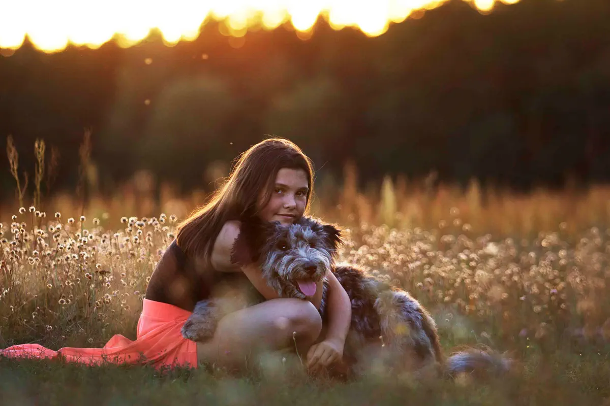 Kind kuschelt mit Hund